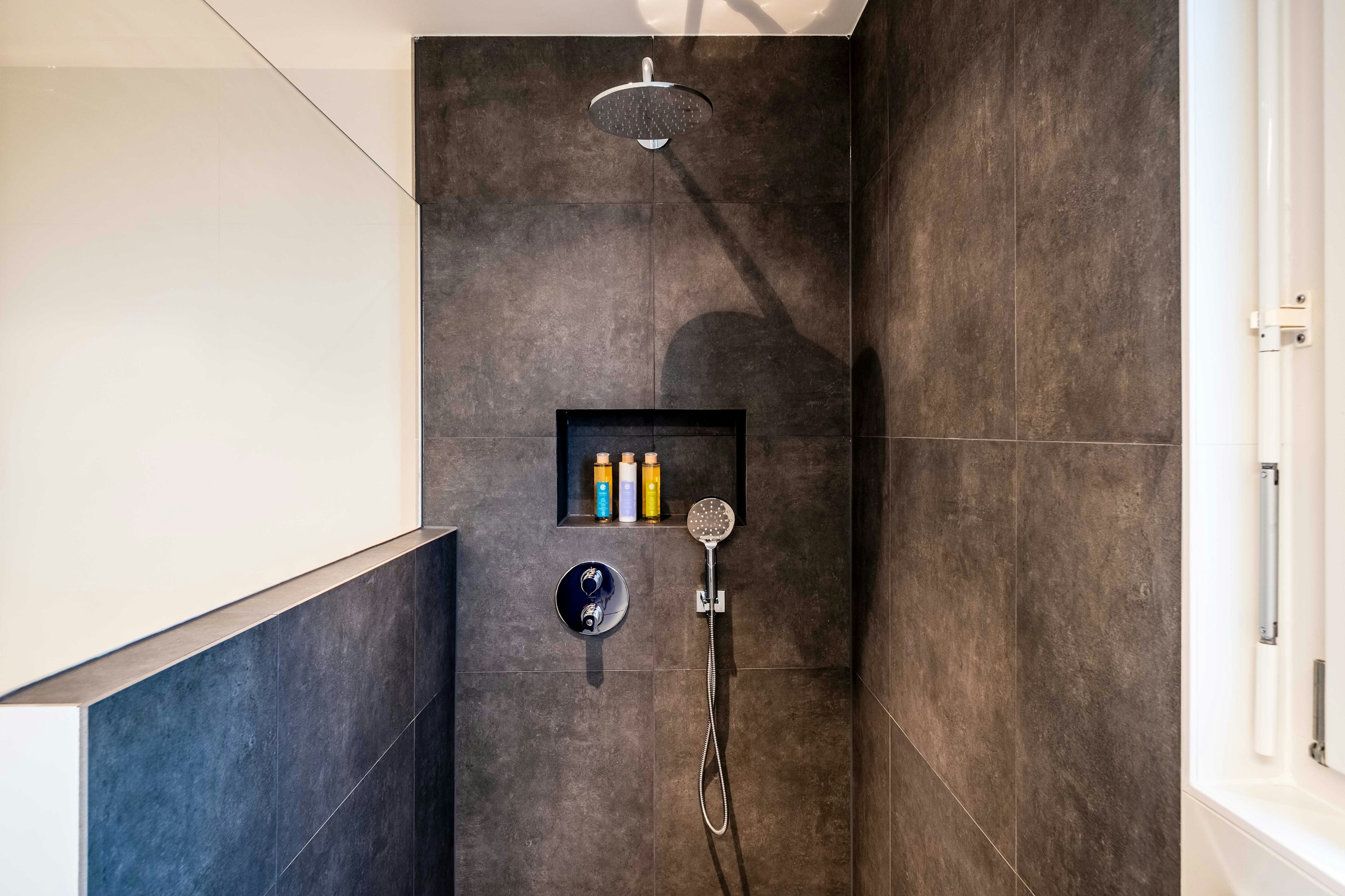 Douche à l’italienne en grands carreaux sombres avec niche